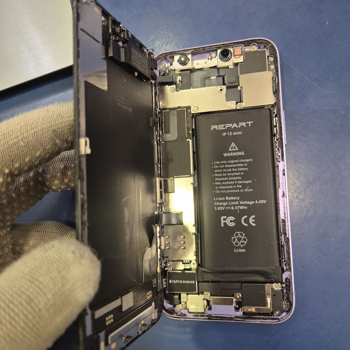 Wymiana baterii iPhone 12 mini w serwisie TELFOX Siemiatycze — otwarty telefon ze starą baterią po wcześniejszej wymianie