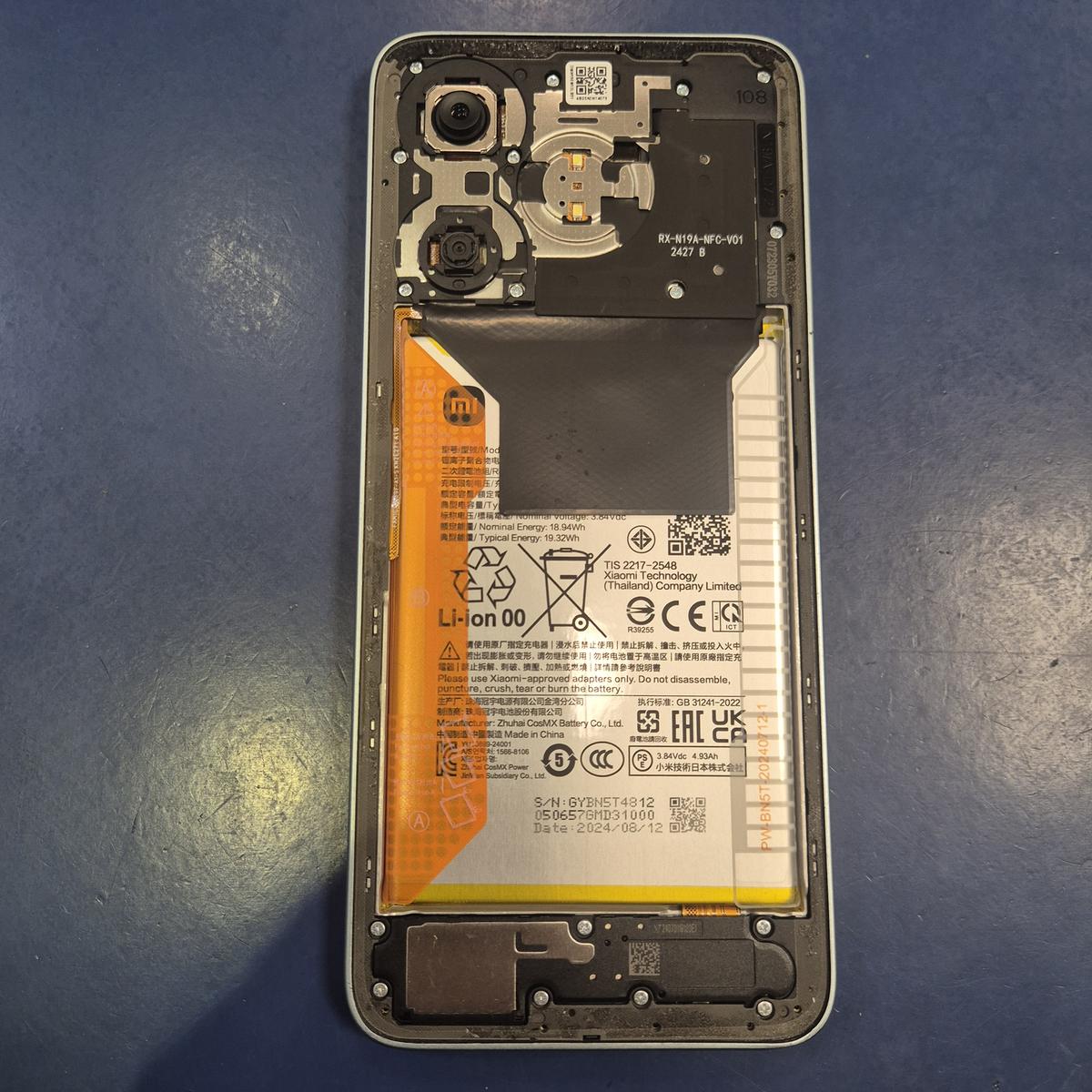 Xiaomi Redmi 13 otwarty od tyłu na stole serwisowym TELFOX w Siemiatyczach — bateria, cewka NFC i aparaty przed wymianą ekranu